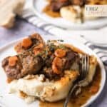 A plate of slow-cooked beef shark in red wine sauce with creamy mashed potatoes.
