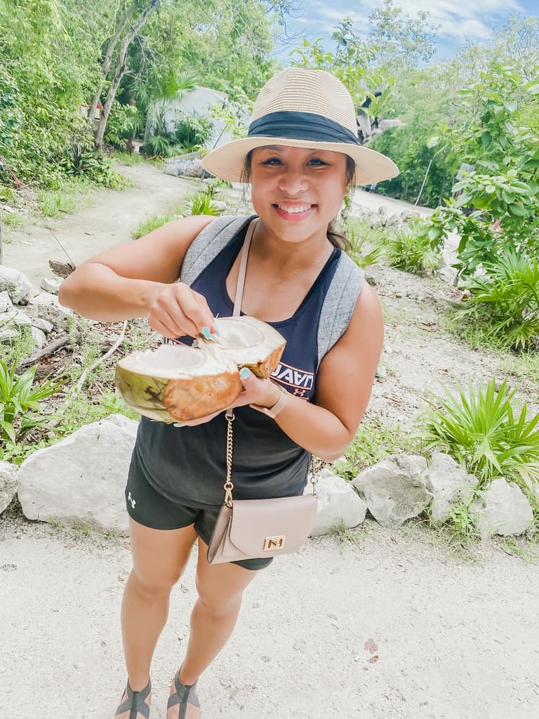 Janice is eating a coconut in Tulum Mexico