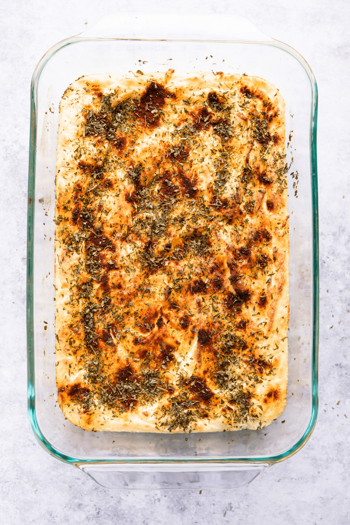 A tray of baked mashed potatoes with herbs.