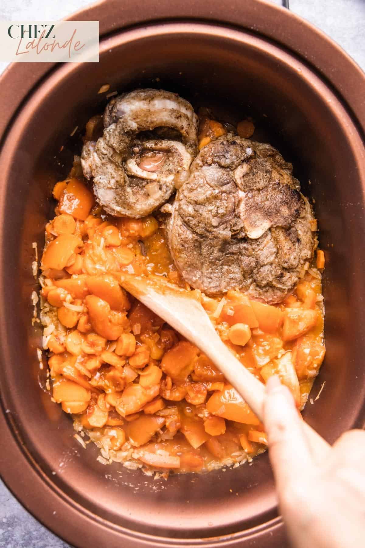 Place the seared beef shanks back into the pot alongside the sautéed mirepoix.