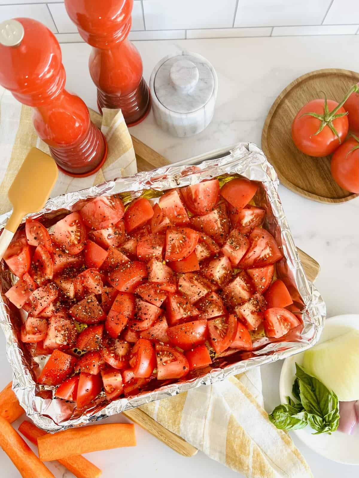 A tray of chopped raw roma tomatoes and other vegetables