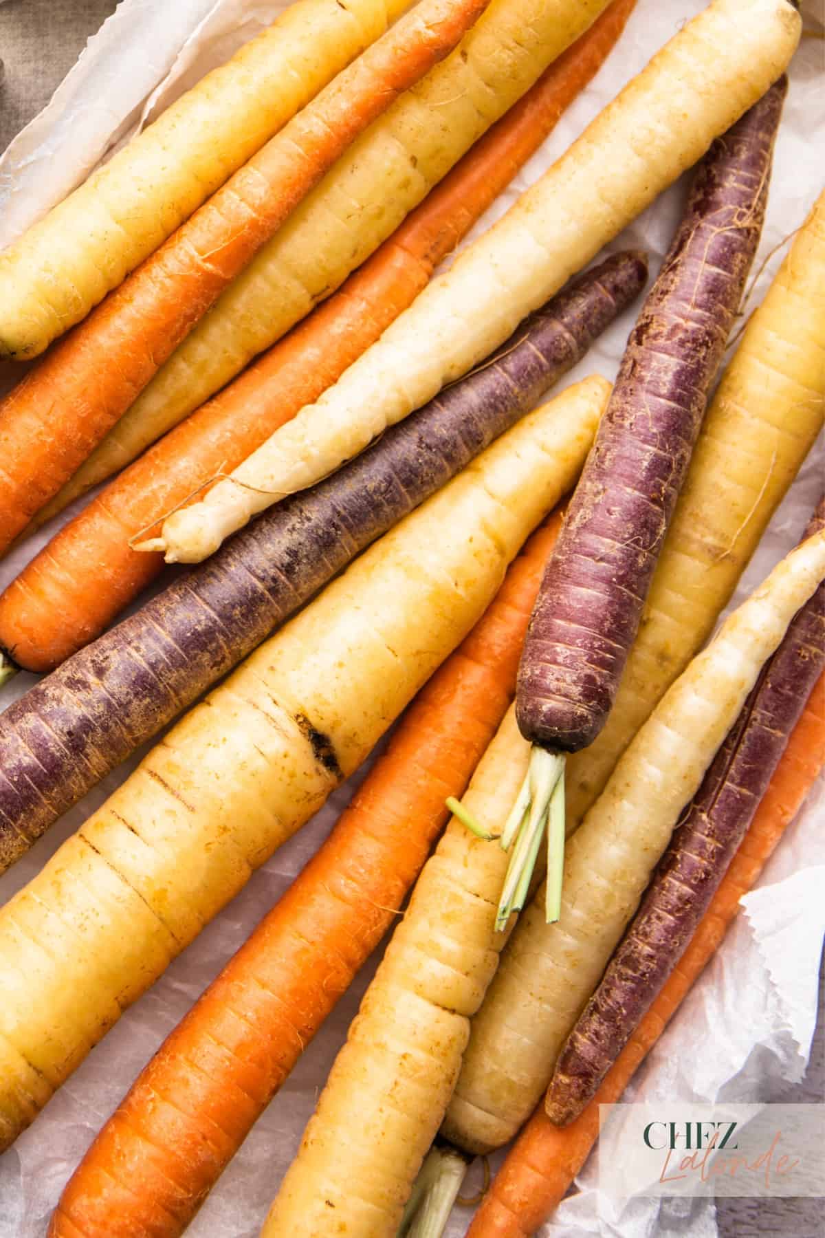A tray on uncooked rainbow carrots