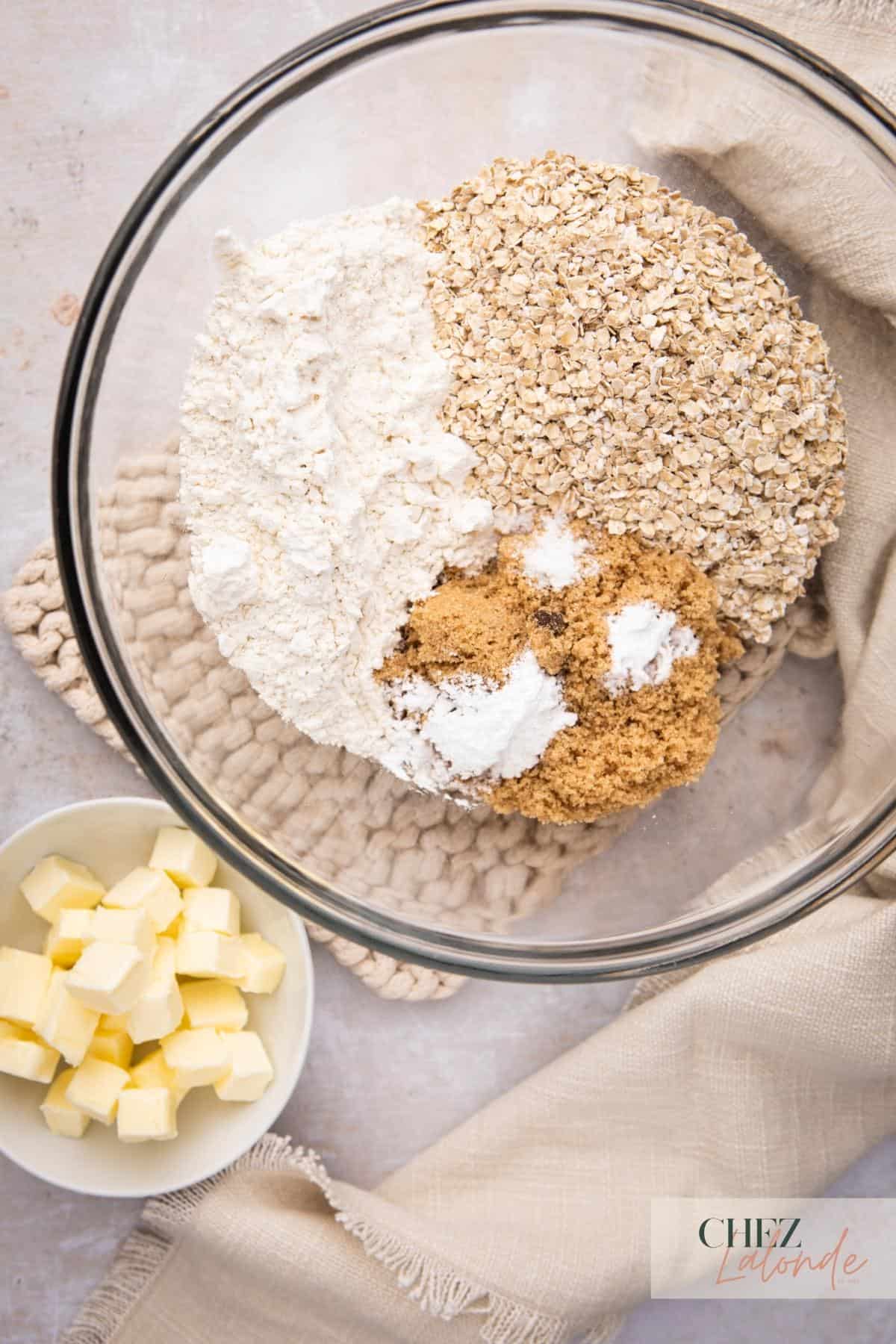 A bowl of oatmeal, butter, and other ingredients.