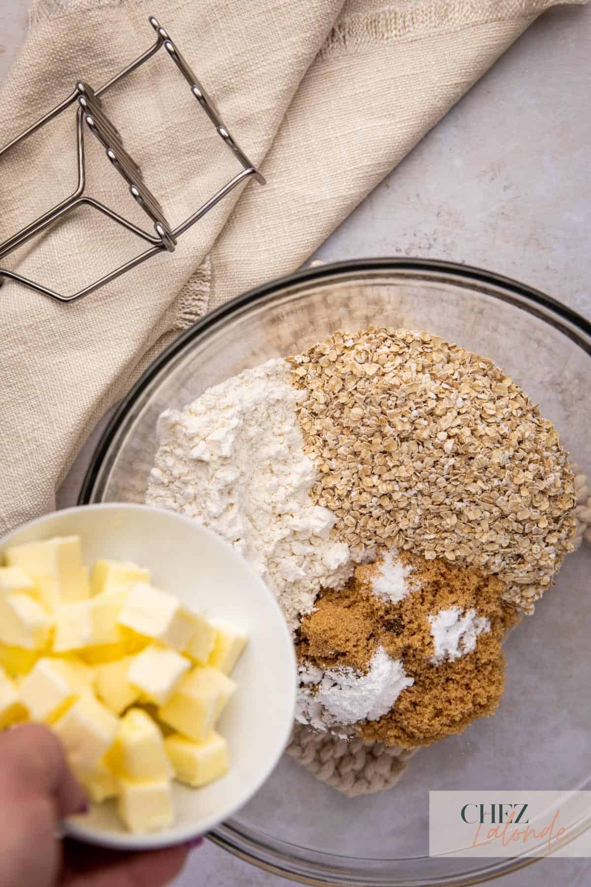 A bowl of oatmeal, butter, and other ingredients to make oatmeal toppings.