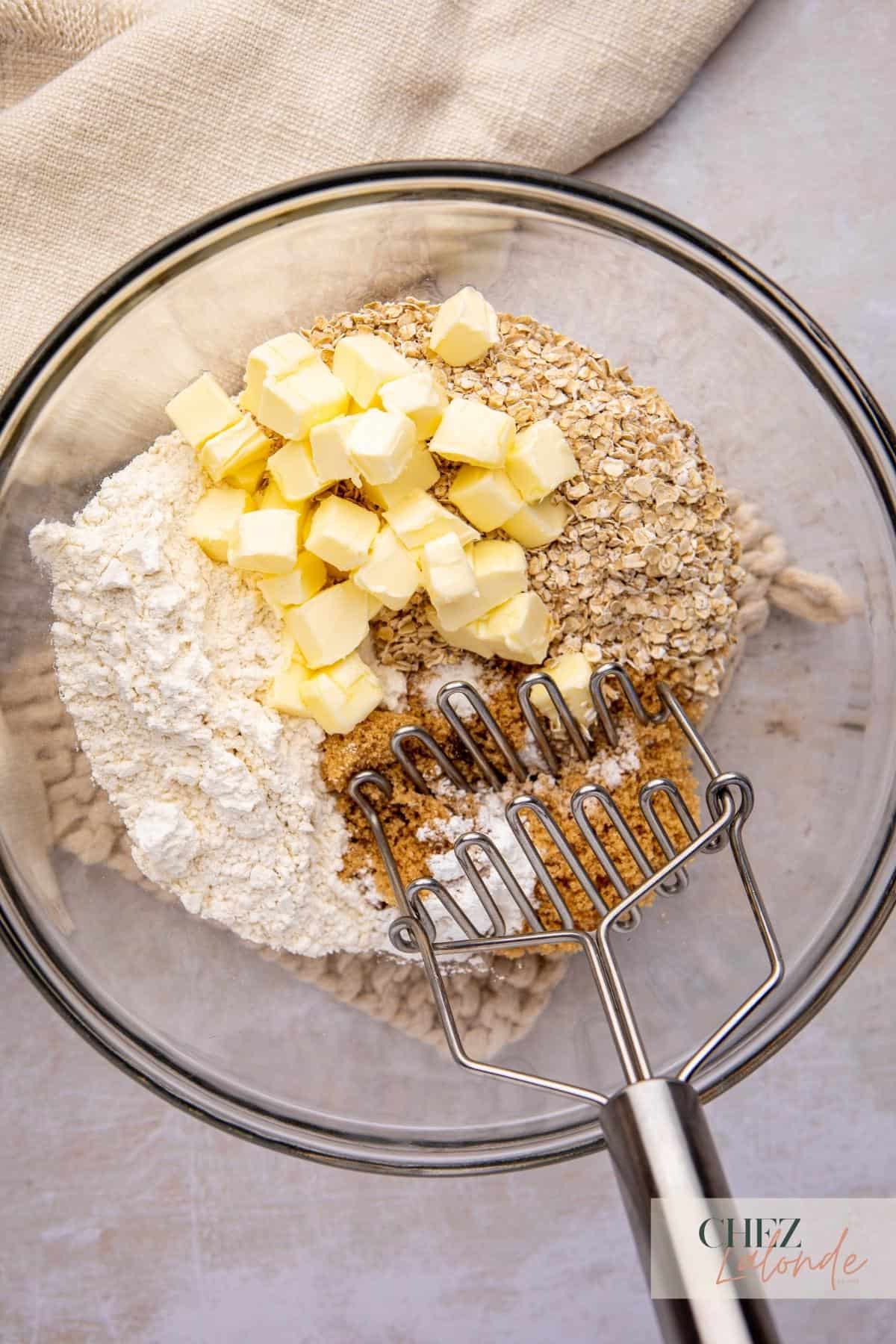 A glass bowl filled with oatmeal, butter, and other ingredients.