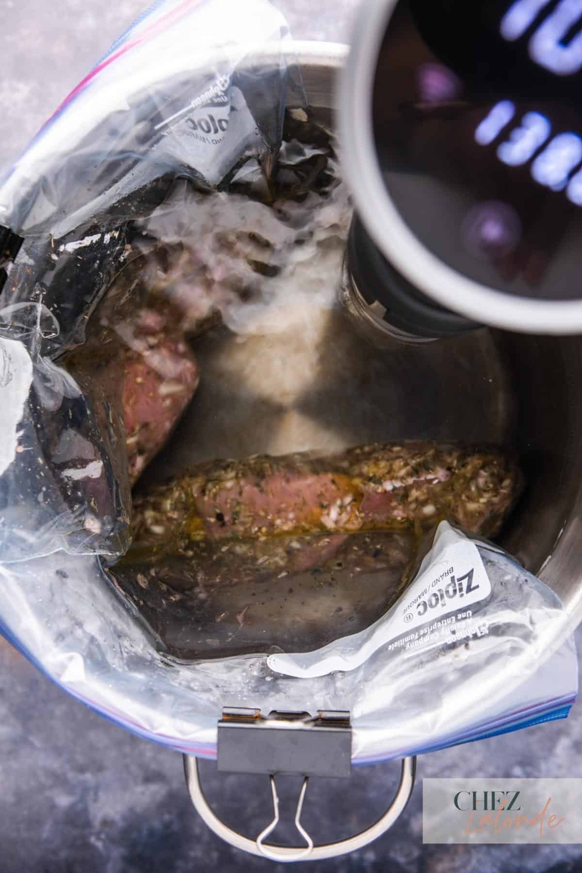 Sous Vide Water displacement method. By submerging the sealed bag of food in the water bath. 