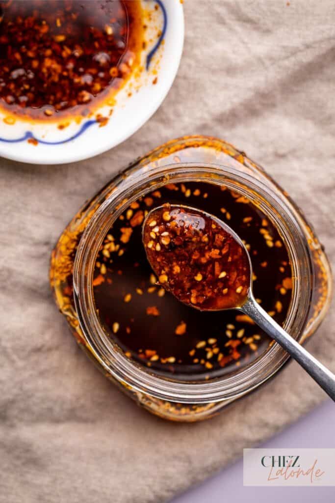 A jar of homemade Chinese Chili oil with a spoon.