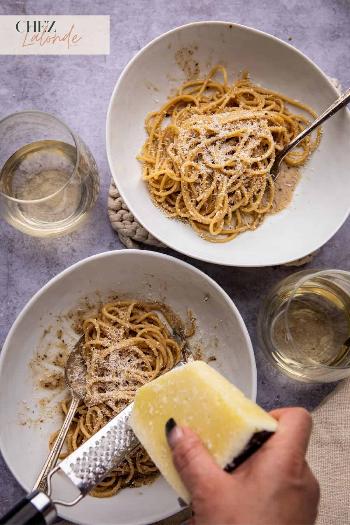 grating pecorino cheese on cacio e pepe pasta.
