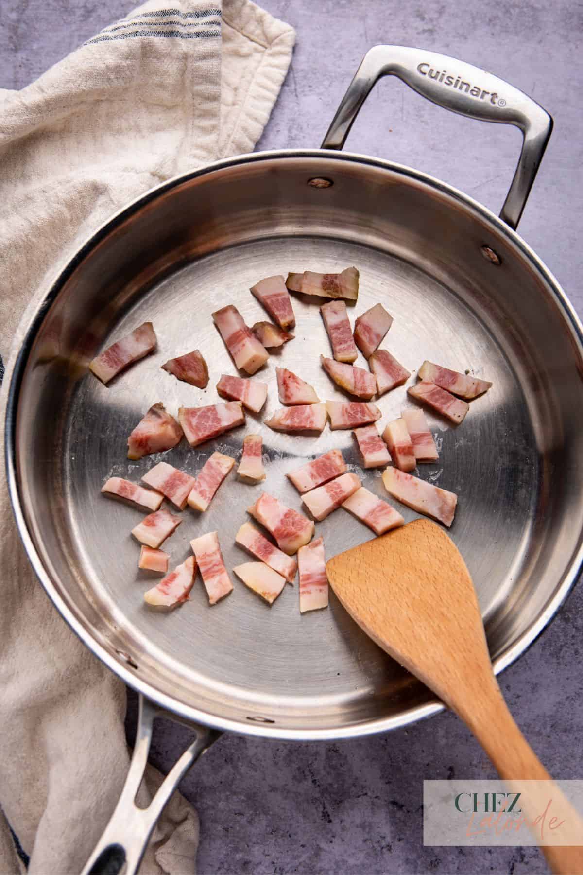 Searing strips of guanciale in a big frying pan. 