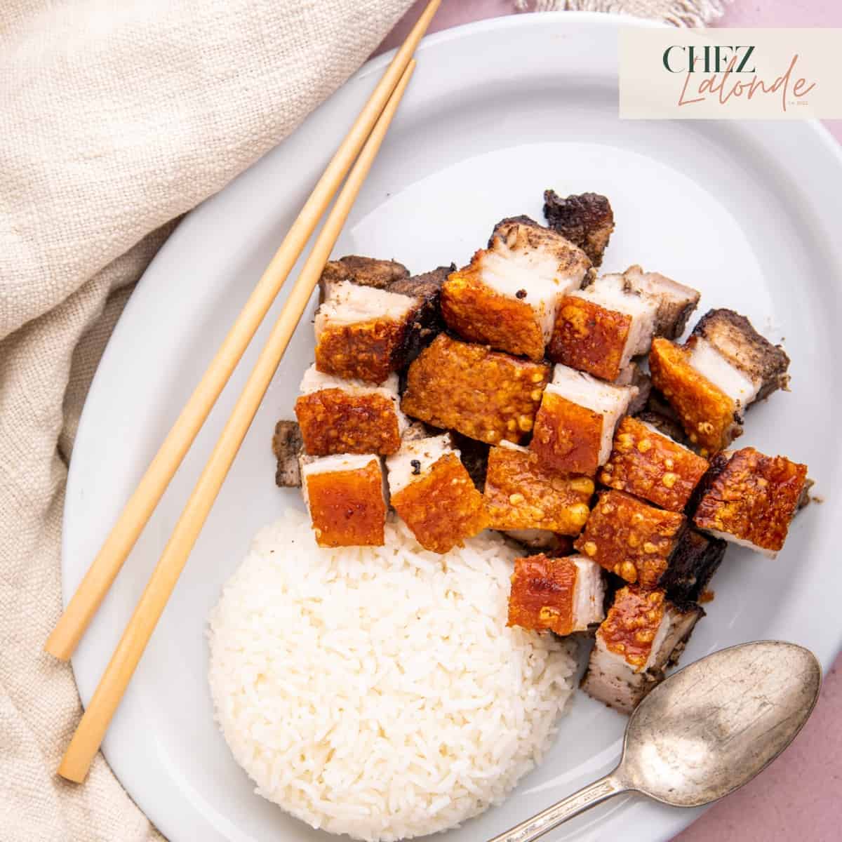 A plate of crispy air fryer Cantonese style pork belly served with white rice.