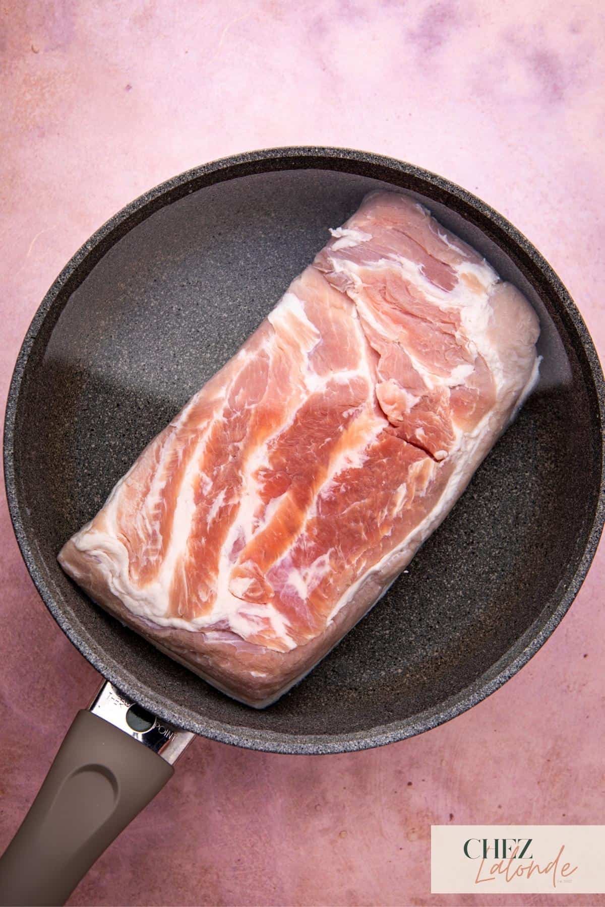 Pre-boil the pork belly in a wok to remove impurities. 