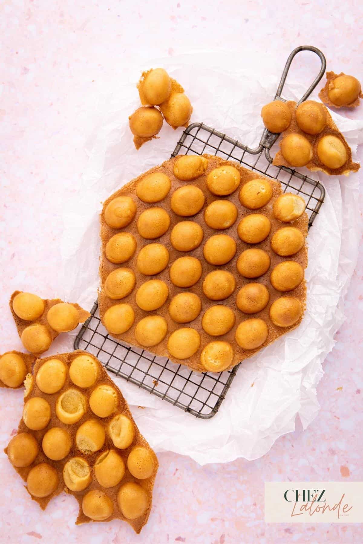 Hong Kong Style bubble waffles on a cooling rack and parchment papers. 