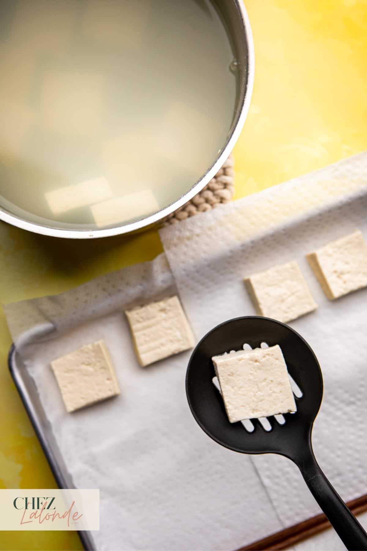 After cooking the tofu for 5 minutes, use a ladle to scoop out cooked tofu and place them on a cooking tray that lined with paper towels.