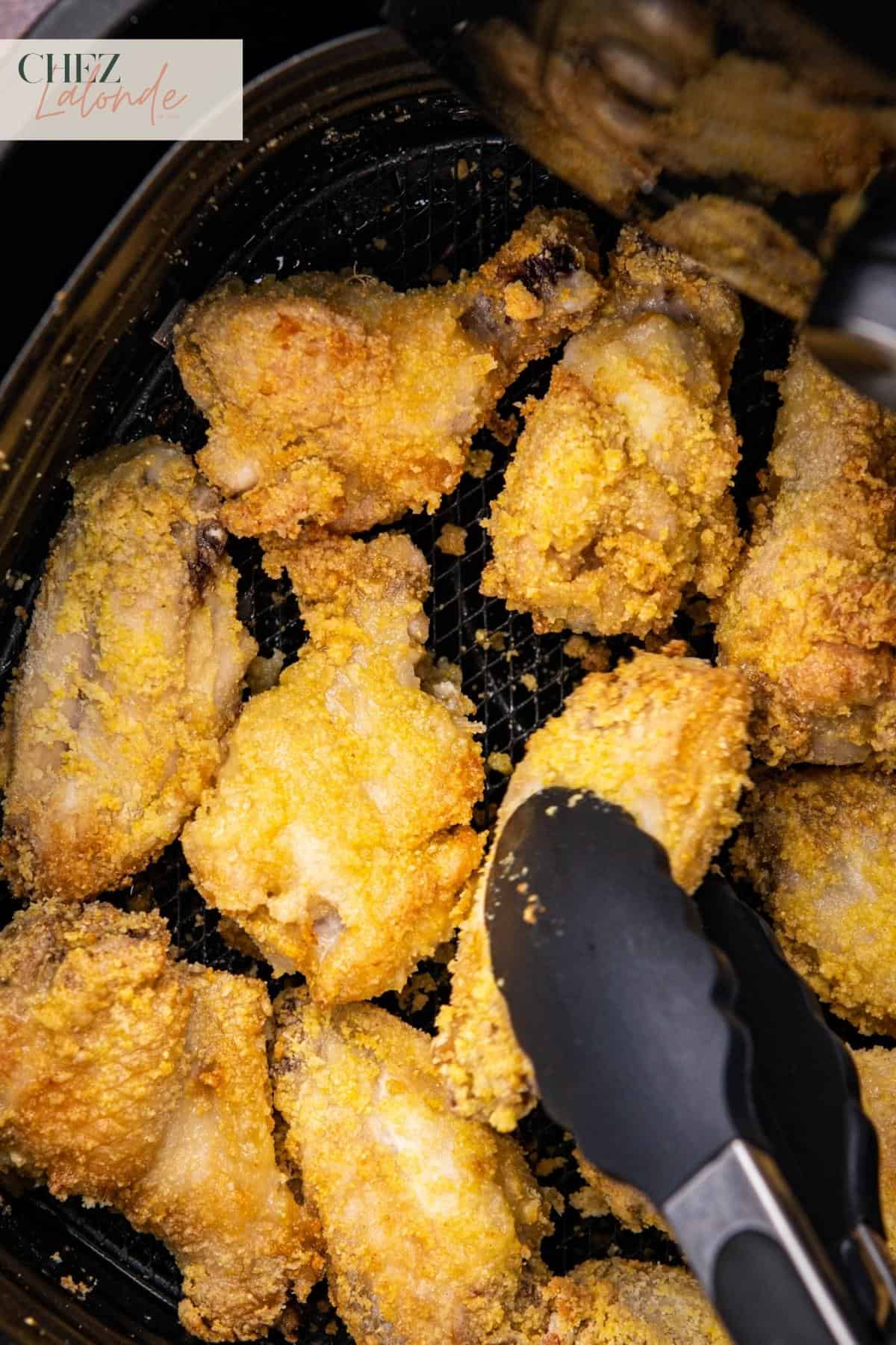 Flipping chicken wings mid way through cooking in air fryer.