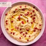 A bowl of Baba Ganoush that garnished with Pomegranate seeds, toasted pine nuts and drizzled with extra virgin olive oil.