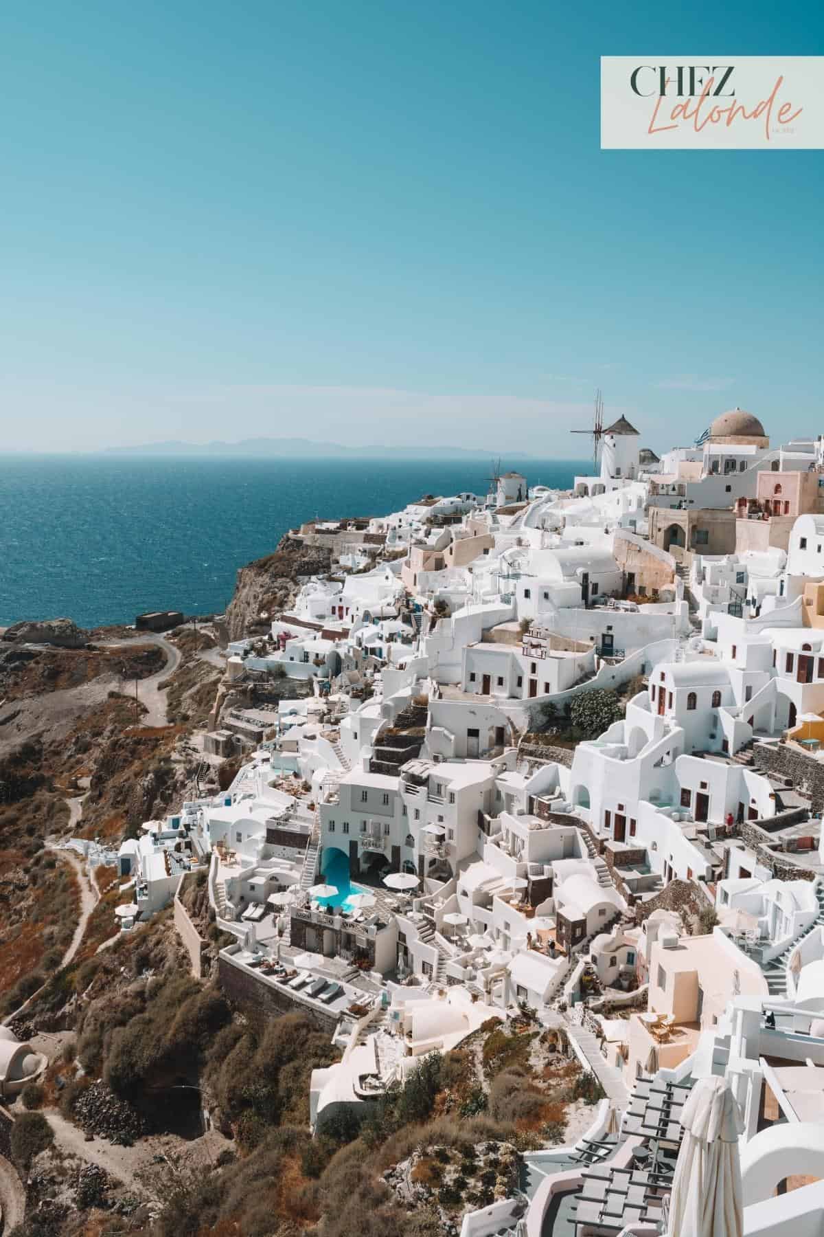 A view of white houses in Greece next to the ocean. 