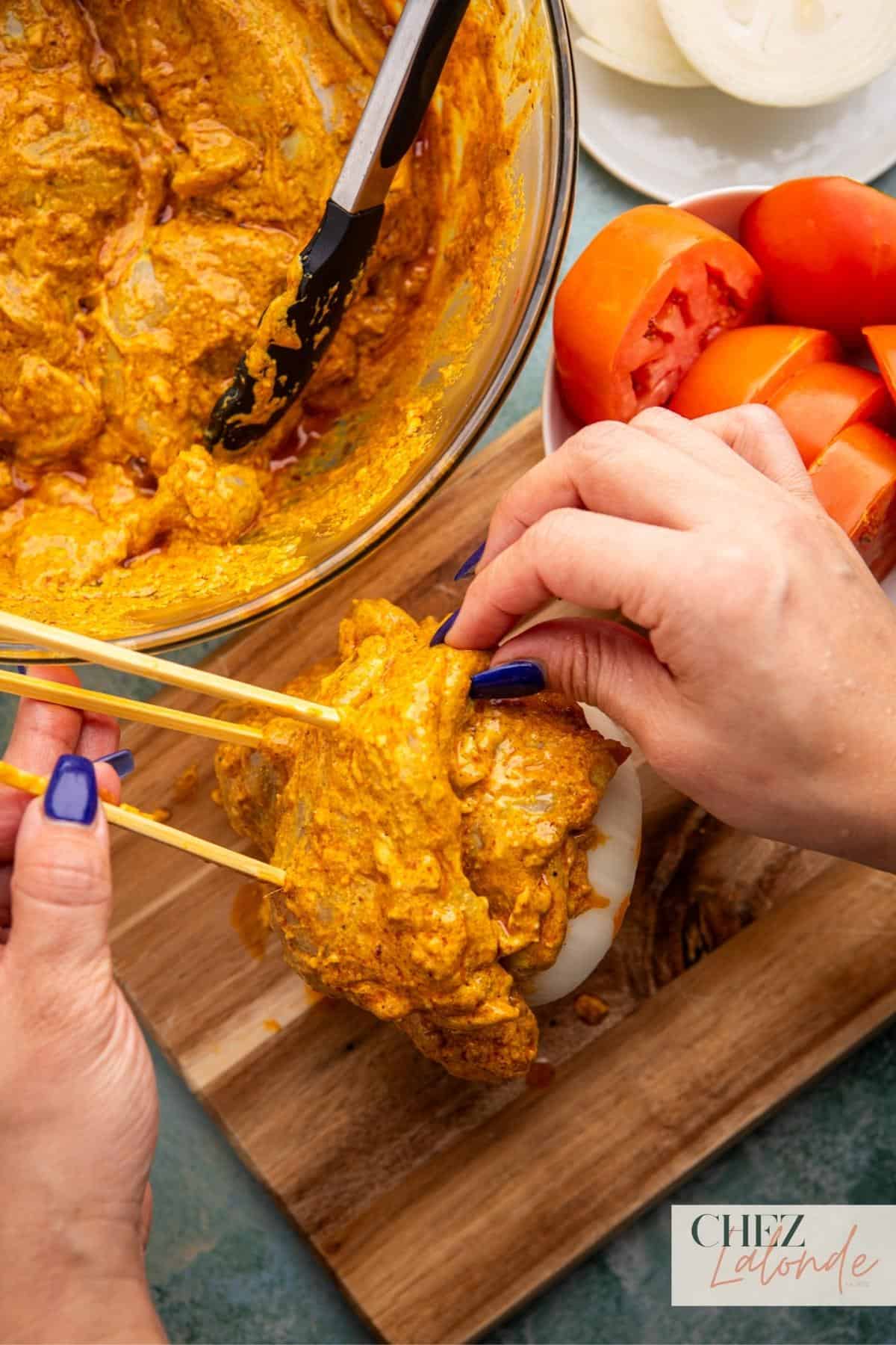 Thread the marinated chicken thighs onto the skewers, stacking 2 to 3 chicken thighs for each layer. Repeat the process, adding another thick slice of onion and some tomatoes, followed by another layer of chicken thighs.