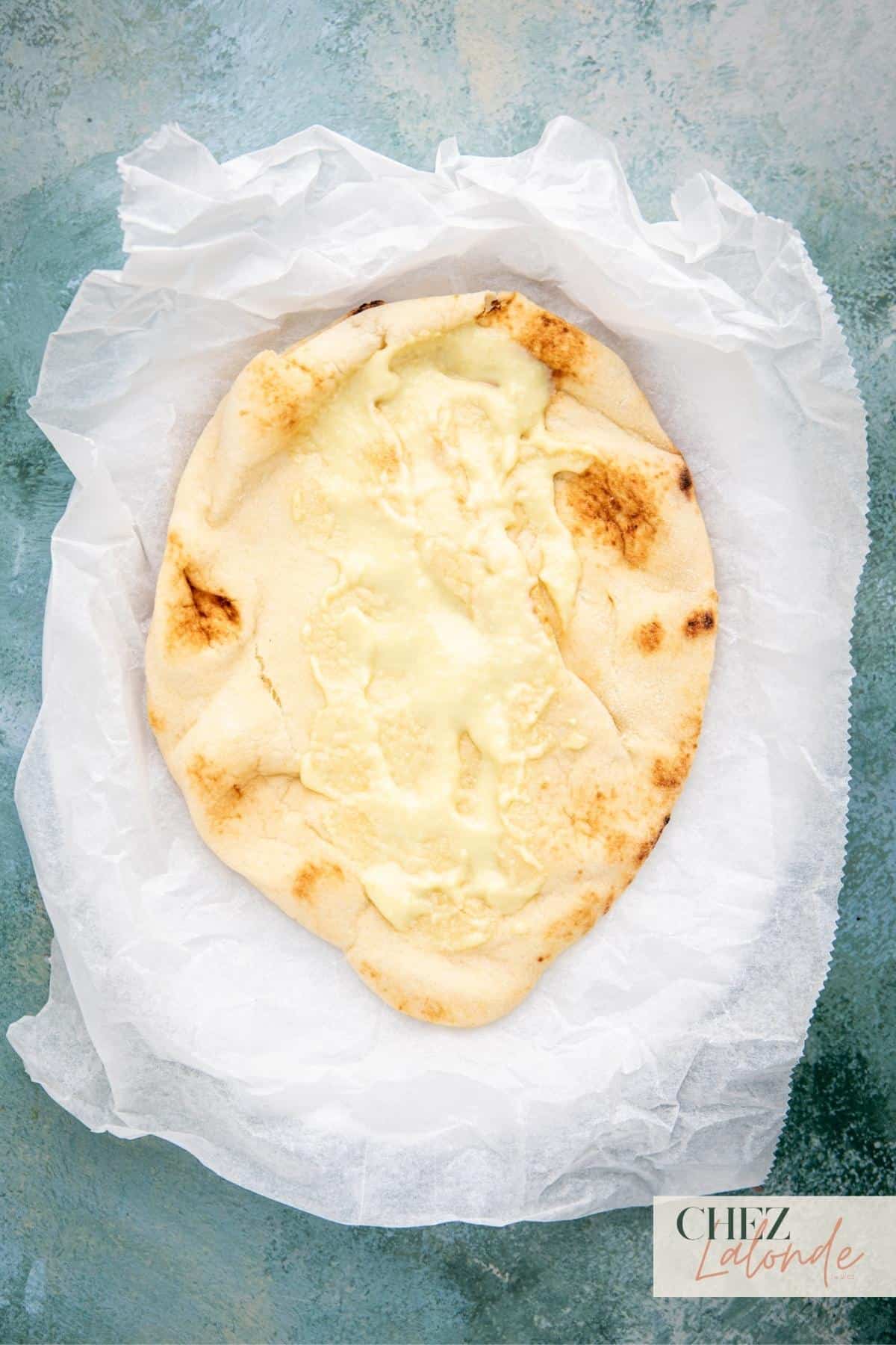 Start with a warm, soft flatbread like Naan, pita bread, or lavash. Spread some Middle Eastern garlic sauce in the middle .
