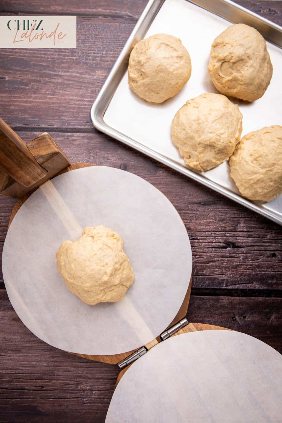 Place a layer of parchment paper between the press and dough to prevent sticking.  Place a pita dough in the middle. 