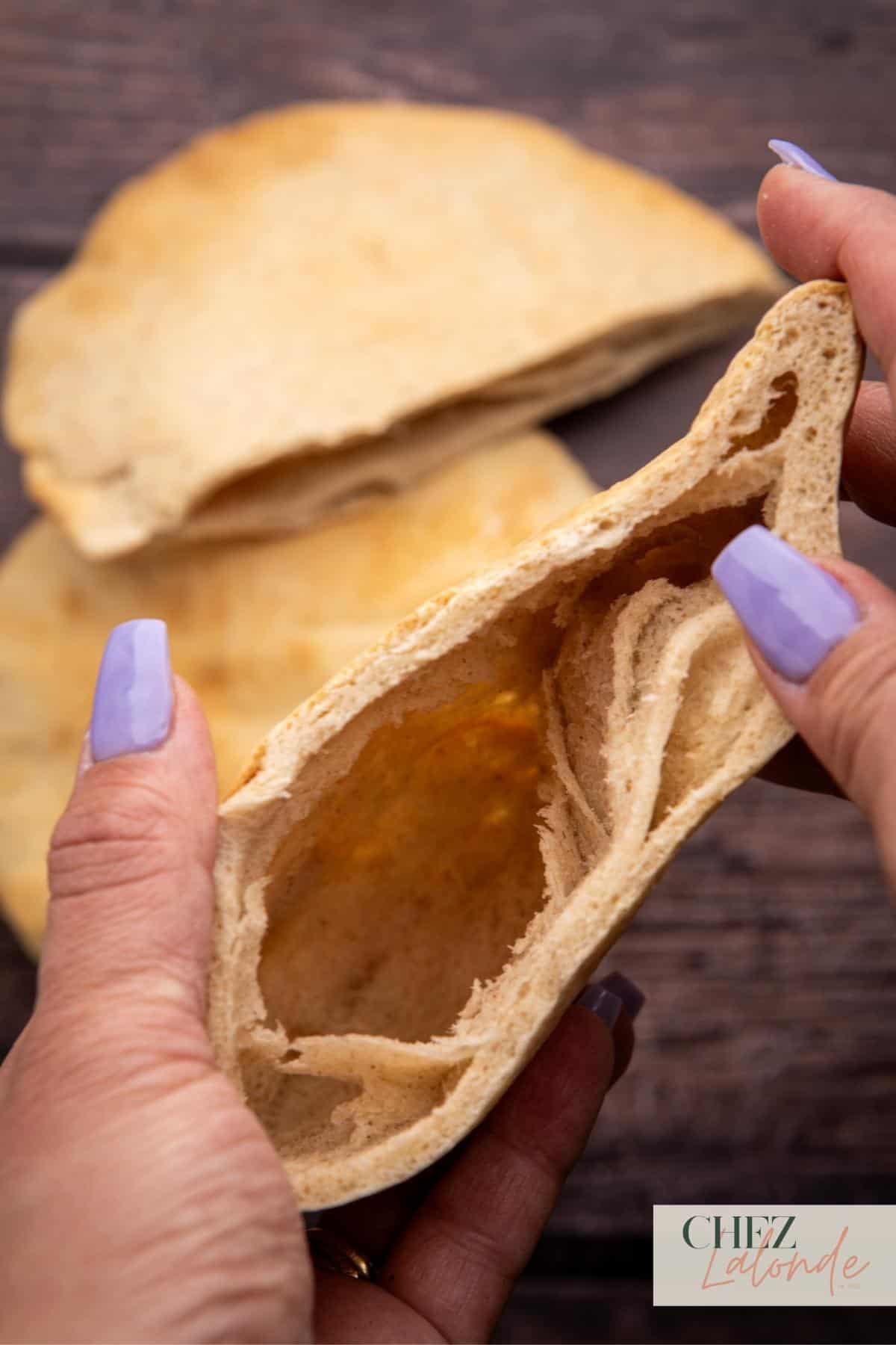 A cut open pita and this picture is showcasing what inside the pita bread looks like. 