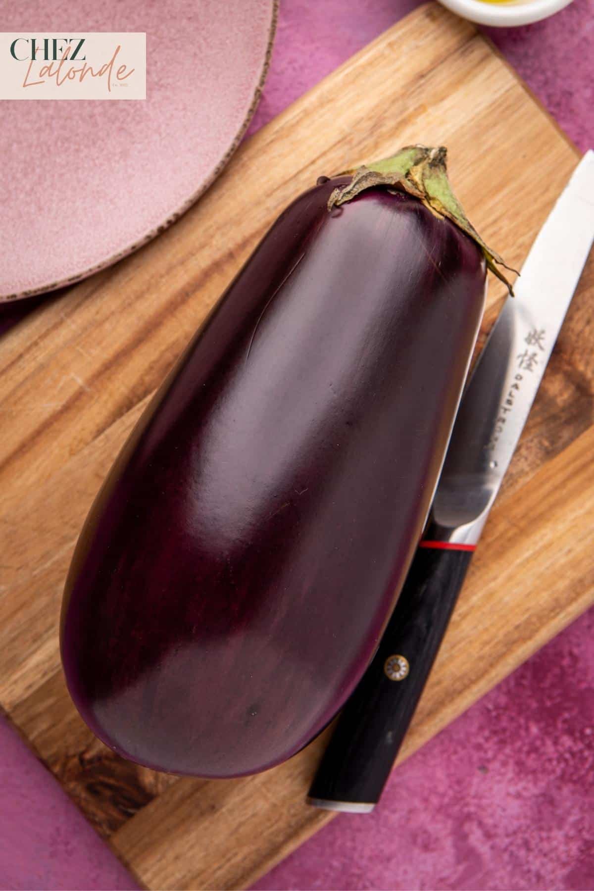 A Globe eggplant on a chopping board. 