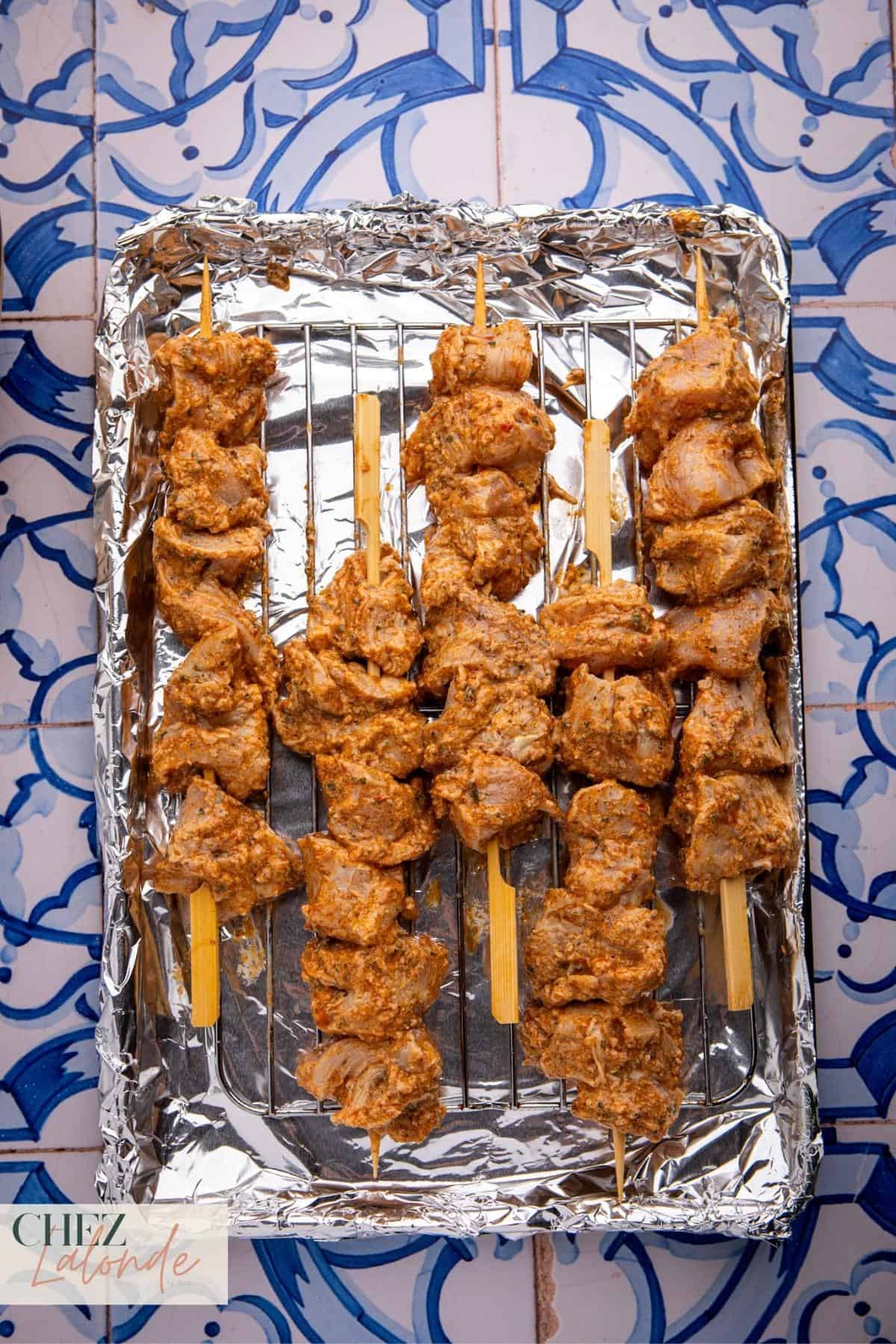 start by lining a baking sheet with foil for easy cleaning. Place a metal rack on top and give it a quick spritz of cooking spray to prevent sticking. Arrange your skewers with space between them for even cooking.