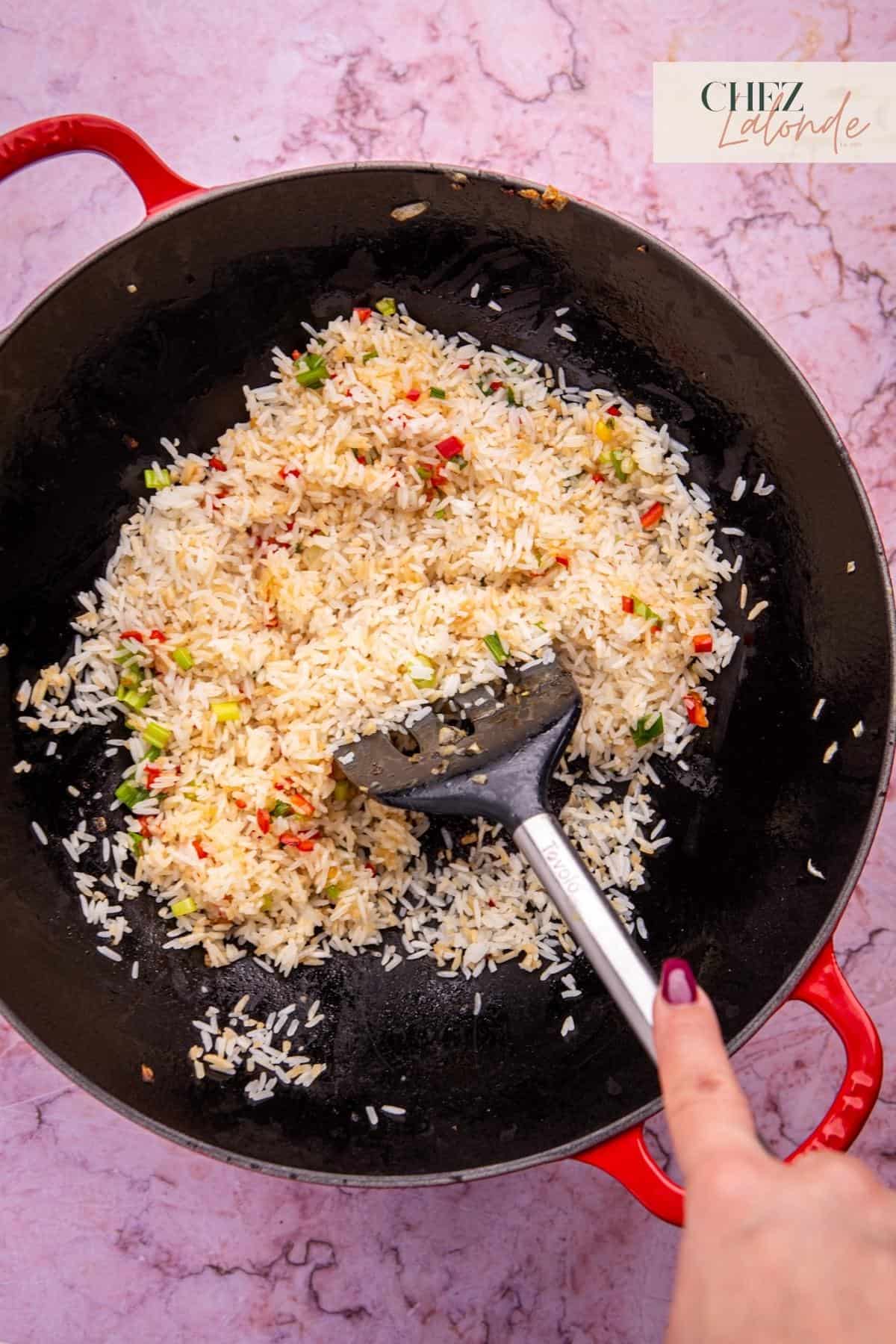 Mix in the rice, breaking up clumps with a spatula. Cook for about 2 minutes, and keep stirring to prevent sticking.